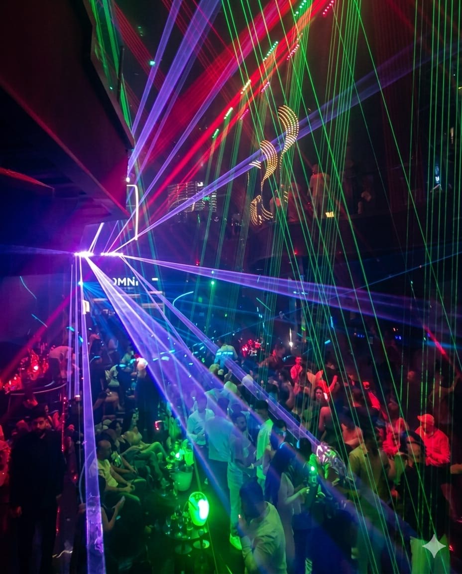 Green and purple laser beams crossing the nightclub dance floor